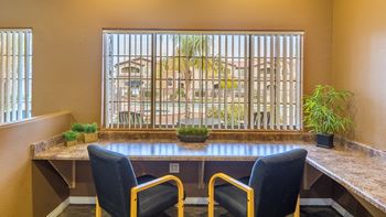 Desert Sands business center with a big window in front of table and chairs. 